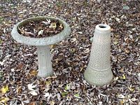 Full view of concrete bird bath with pedestal and separate extra pedestal base, showing decorative patterns and weathering