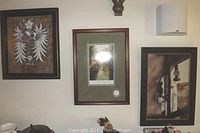 Three framed artworks shown hanging on a wall: one central taller framed aquatint signed by Fabio Baldan with a certificate of authenticity, flanked by two other framed prints.
