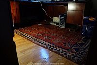Area rug under office desk, showing geometric pattern and wear on the left corner.