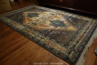 Angled view of full rug on hardwood floor showing overall design and pile condition