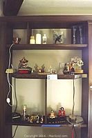Shelf display showing carousel music boxes, brass bookends, and assorted figurines.