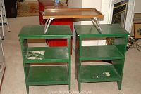 Two green wooden bookcases side by side showing shelving and paint wear.