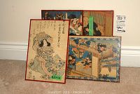 Four framed Asian themed vintage art sketches placed on floor, with one showing broken glass.