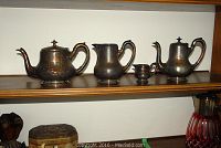 Group shot of four service pieces on wooden shelf showing all items