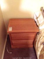 Wooden nightstand front view showing two drawers and wood grain finish.