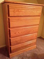 Front view of the five drawer tall boy dresser showing the wood grain finish and drawer design