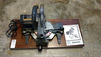 Front-down view of the Craftsman radial saw on wooden base showing the blade, handle, and power cord.