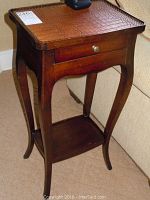 Wood side table with curved legs, single drawer, and textured faux alligator skin top