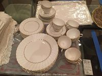 Overall view of stacked dinner plates, saucers and coffee cups on glass table