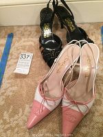 Chanel pink and white slingback heels with visible logo embroidery and bow detail with Ferragamo black and tan animal print slingbacks behind