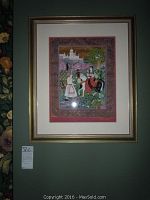 Full shot of the framed fabric art on wall showing entire 18.5 x 22 inches piece with gold frame and mat.