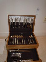 Open wooden flatware chest showing upper and lower trays with Reed & Barton Tara pieces