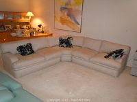 Full view of the sectional sofa in the living room showing the corner section and two sides with floral cushions placed.