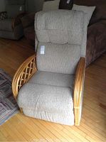Front view of beige upholstered recliner showing overall design and pull lever on right side