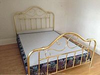 Full view of brass-tone headboard, footboard, side rails assembled with box spring