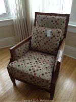 Front view of armchair with patterned upholstery and wooden frame