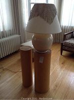 Overall view of ceramic lamp atop two wooden podiums