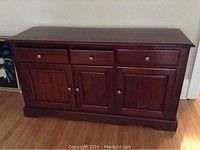 Front view of server showing three drawers above three paneled cupboard doors with silver knobs.