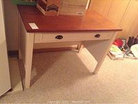 Full view of desk showing wood top and white frame with drawer closed.
