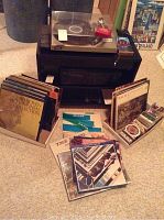 Record player on entertainment stand with Yamaha stereo receiver and vinyl records displayed around it