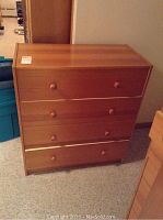 Front view of one pine dresser showing three drawers with round wooden knobs and natural wood finish.