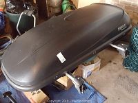 Cargo box on floor with mounting hardware and crossbar clamps