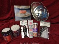 Photo showing Wilton wedding couple cake toppers, containers of confetti sprinkles, pink decorating icing tube, Santa face cake pan, and cupcake cookbook.