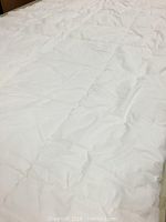 Close-up photo of a white queen size duvet showing quilted pocketed design and fabric texture
