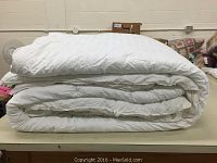 Folded white king size duvet, showing thickness and texture.
