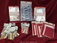 Overview of wedding supplies including card sets, ribbon bows, tags, and magnets displayed on red fabric background