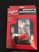 Five new Rawlings black neoprene sports armbands in original red packaging, showing branding and product details.