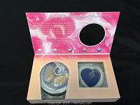 Open gift box showing informational card, drawstring pouch, and pendant