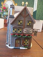 Front side of Kingsford Brew House showing detailed windows, stone-like walls, Christmas garlands, and hanging pub sign.