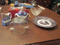 Photo showing the full lot including Gorham crystal bowl, Woods Little Old Lady sugar bowl and creamer, Hocking glass cup with chip and W. Adams transferware plate marked Athens