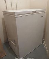 White Kenmore chest freezer shown closed from a side angle, showing exterior design and shape.