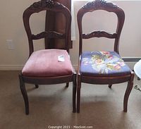 Front view of two wooden balloon back chairs, one with red upholstery, one with floral upholstery.