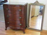 Front view of three-drawer chest and adjacent wall mirror.