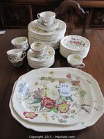Group shot of entire set: stacked plates, cups with saucers and two platters