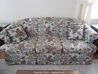 Front view of floral pattern couch with two matching floral throw pillows.