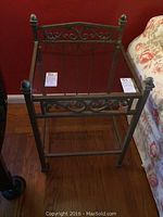 Side table showing metal frame without glass top insert, placed next to floral upholstered furniture