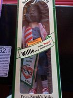 Sarah's Gang Willie doll in original box with front view showing doll wearing striped jacket and denim overalls, heart label present, arms detached.