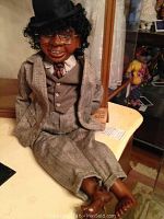Seated walnut wood doll in grey suit, hat and glasses