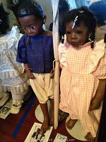 Full view of both dolls side by side on stands