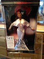 Front view of boxed Diana Ross Barbie doll dressed in white satin gown with bead details and feather hair accessory.