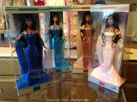 Four Barbie dolls displayed in original boxes, representing birthstones for September, October, November and December, each dressed in jeweled gowns matching their birthstone.