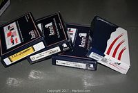 Four black Annin brand boxes labeled with the names of Sweden, Denmark, Albania, and New Zealand flags showing the lot is four boxed flags