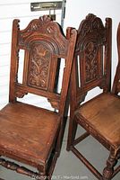 Pair of two solid wood carved chairs with decorative Gothic Revival style backs.