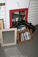 Four framed mirrors together showing two ornate plastic frames in black and gold, one red wooden frame, and one light-colored shabby chic wooden frame.