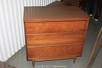 Front view of the dresser showing three horizontal drawers and laminate top.