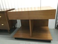 Side view of mid century modern end table showing wood finish, storage compartments and overall rectangular shape.
